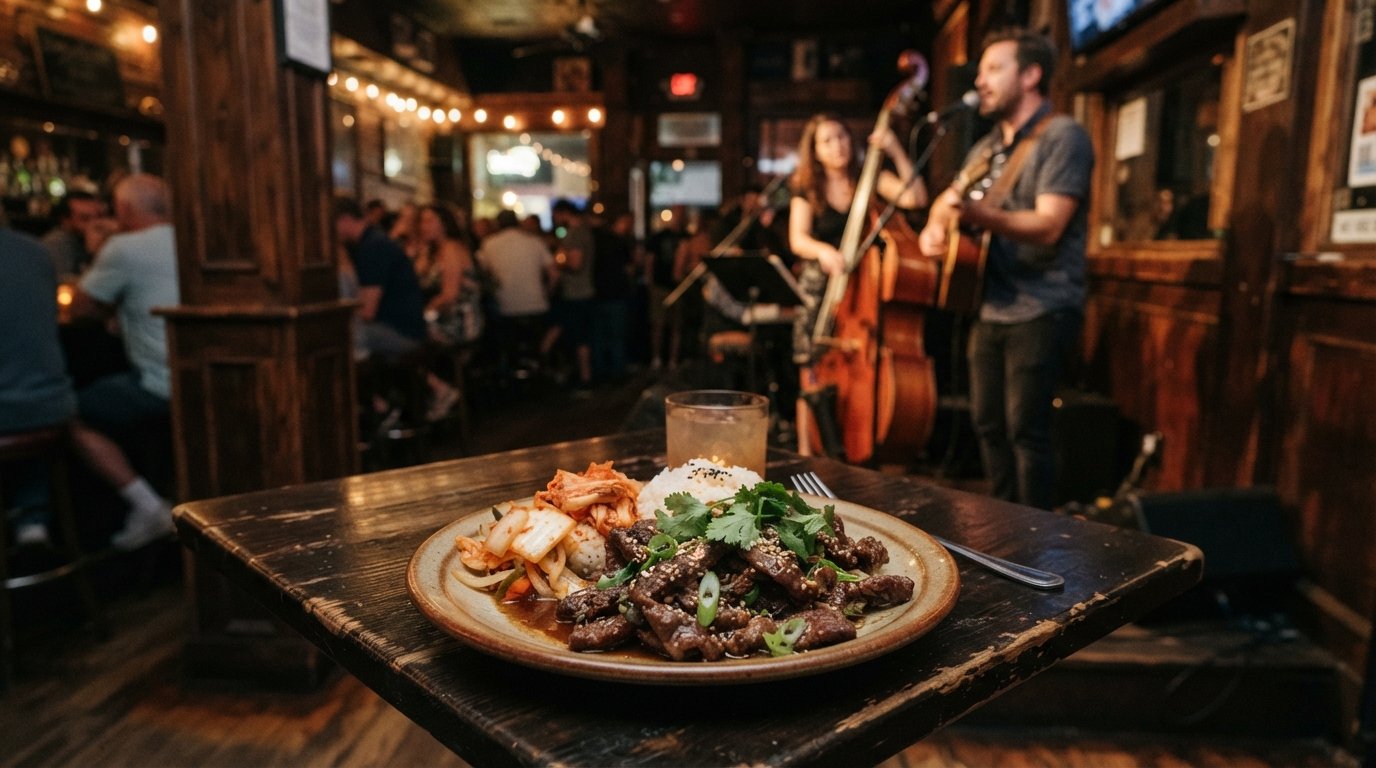 a plated small-plates dinner at Three Muses on Frenchmen, warm bar light, a bulgogi dish in the foreground with musicians blurred behind